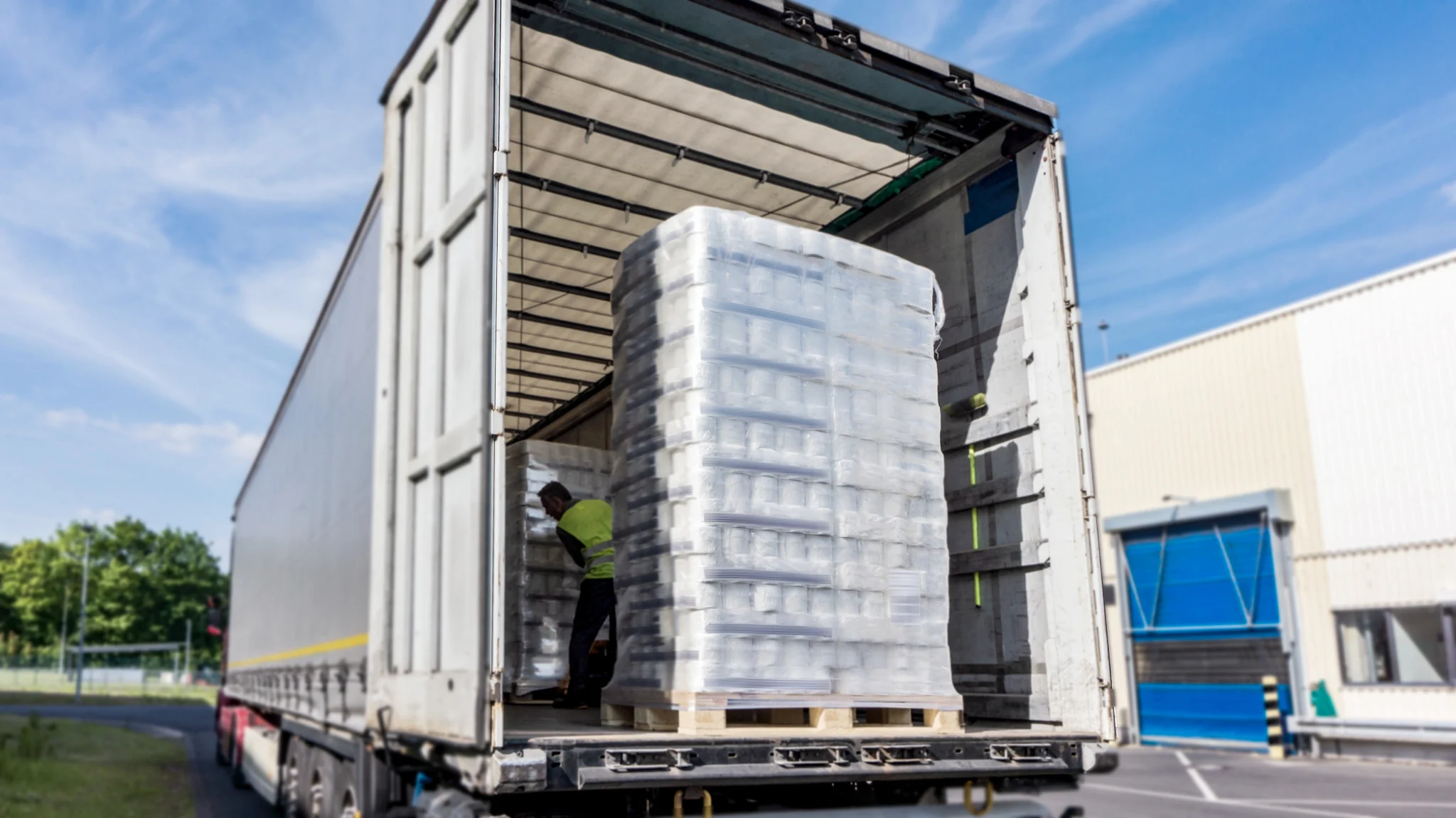 Palletized freight being loaded into a curtain-side trailer