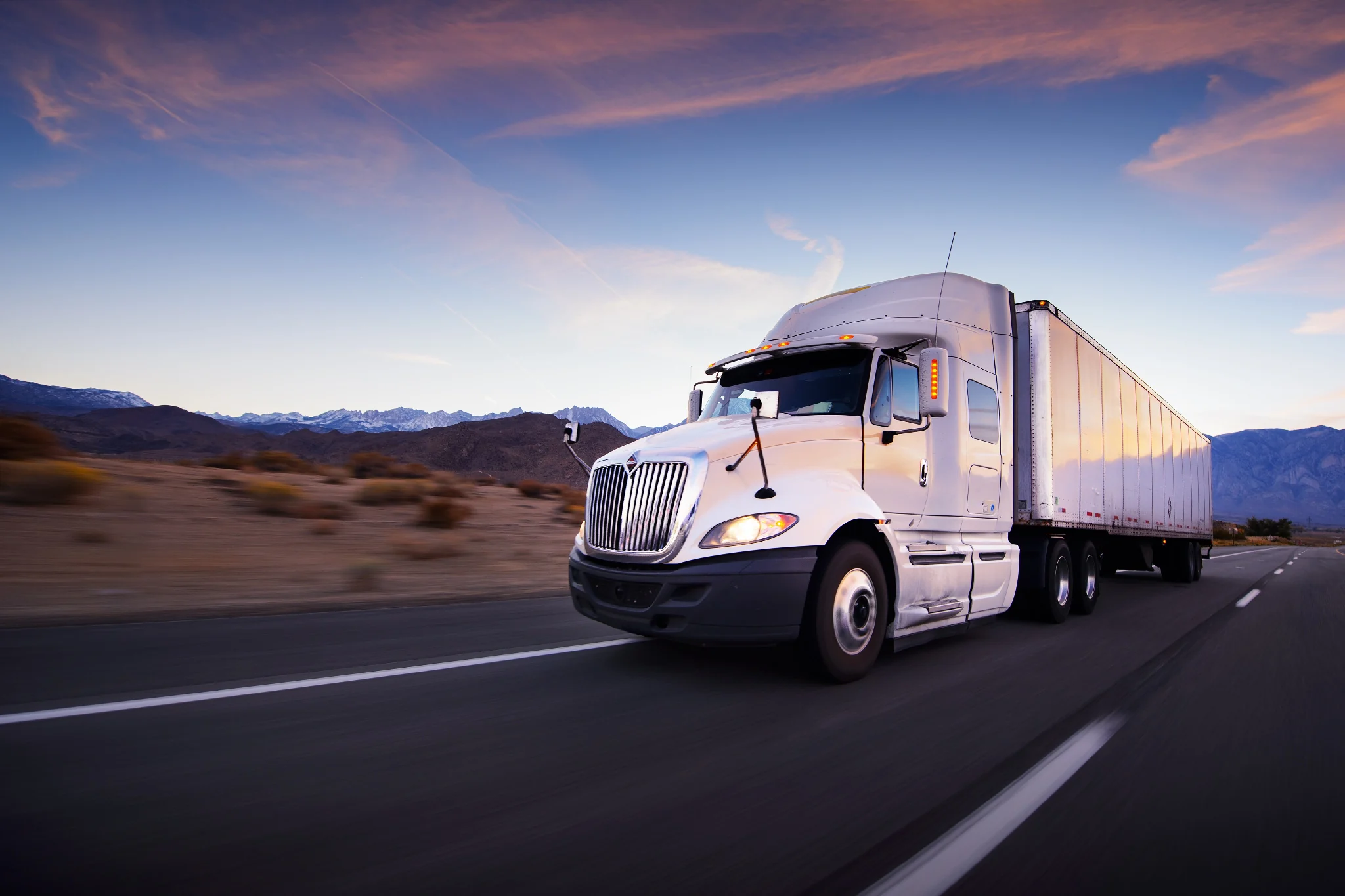 Tractor-trailer moving on a highway at sunset